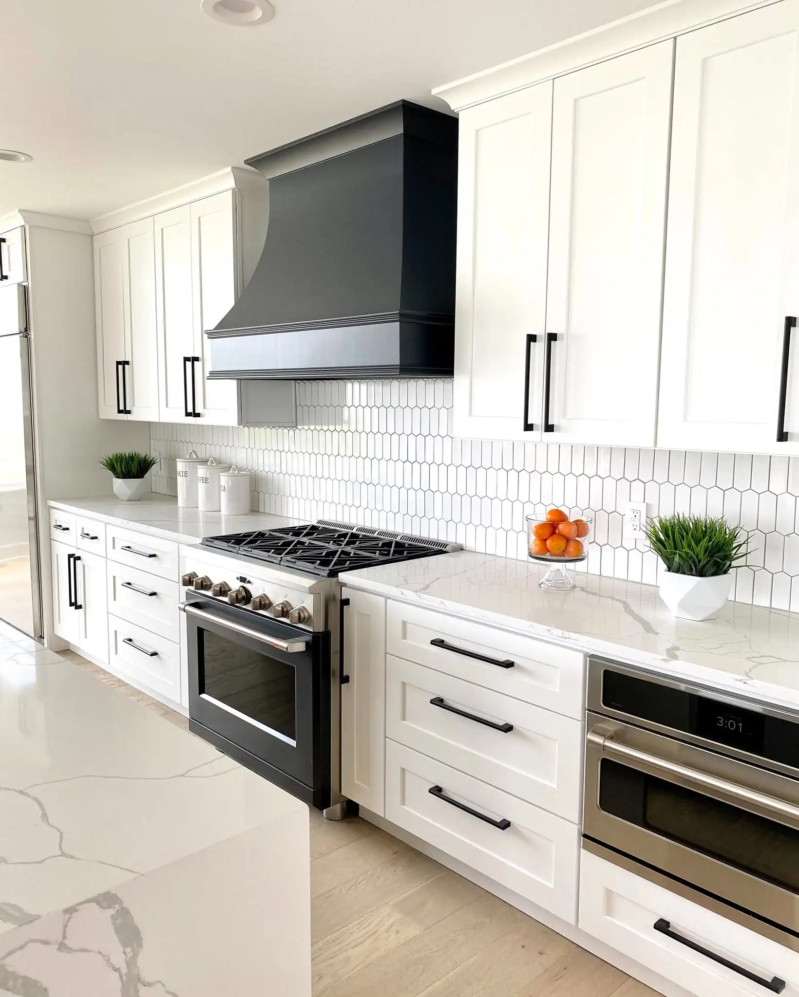 White kitchen cabinets with a black range hood in a Wickliffe Ohio kitchen