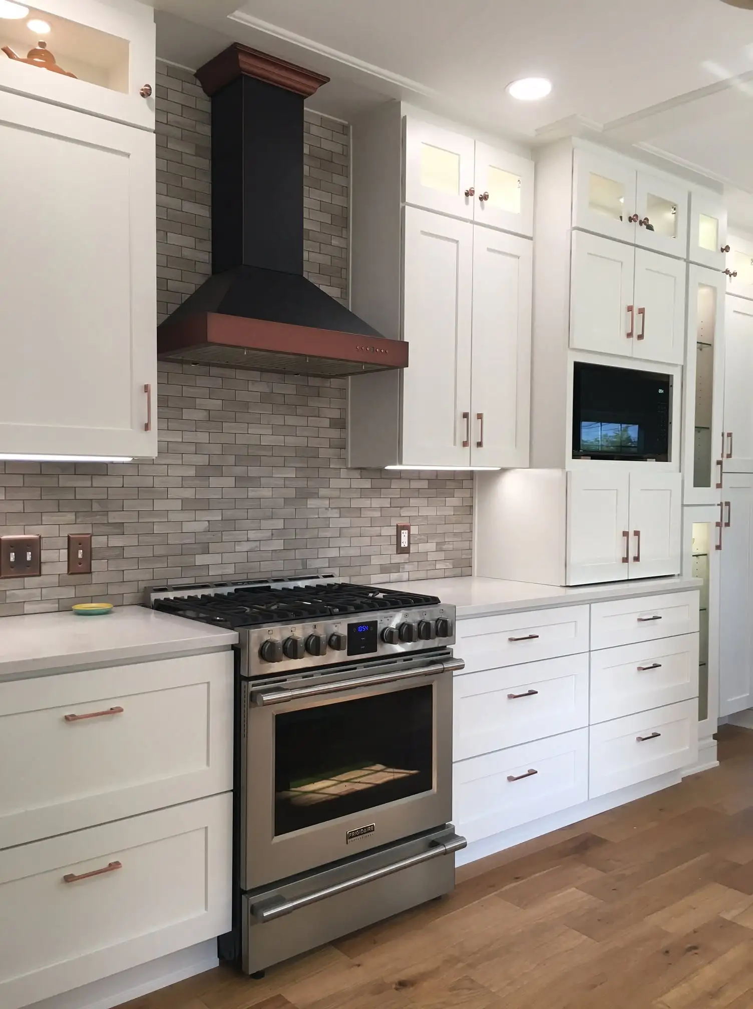 White kitchen cabinets with a copper range hood in a Medina Ohio kitchen